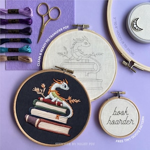 K&ouml;nnte beinhalten: Ein Stickset mit einem Drachendesign, mit einem fertigen St&uuml;ck und einer Strichzeichnung. Enth&auml;lt Stickrahmen, Faden, Schere und den Text "book hoarder". Die Rahmen messen 8 bis 20 cm.