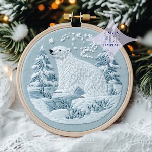 Puede incluir: Arte de bordado en aro con un oso polar blanco de pie en un paisaje nevado con árboles azules y blancos. El aro es de madera y tiene un fondo de tela azul claro. El texto "6 SIZES PDF TEMPLATE" está en una forma de estrella de color púrpura.