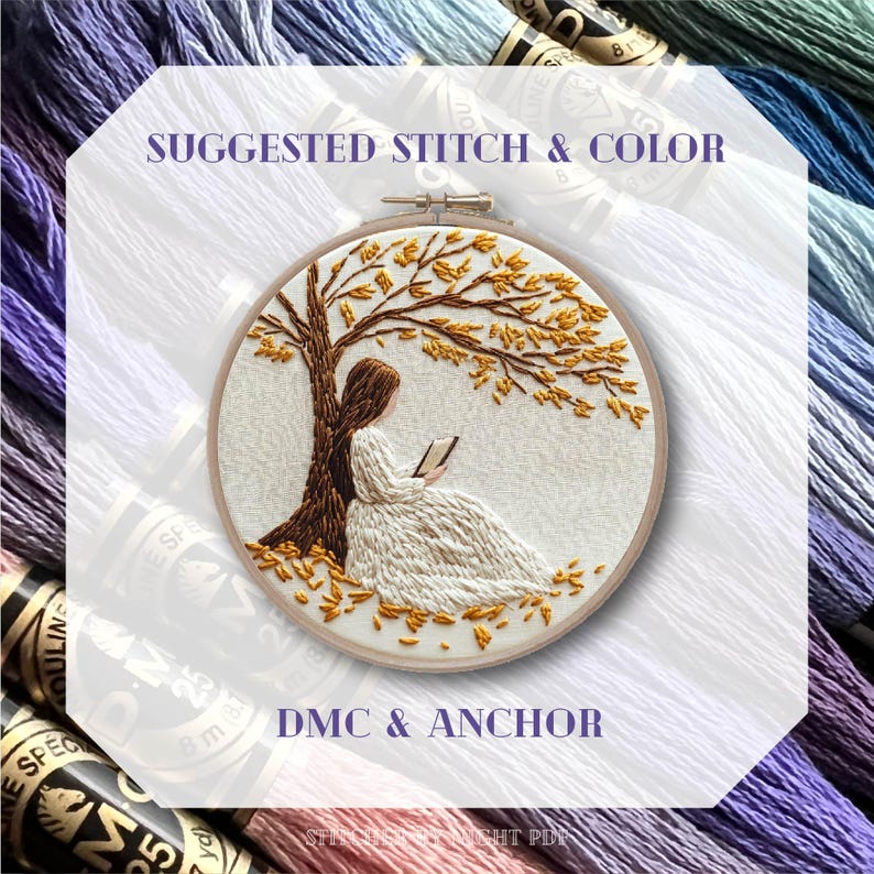 Puede incluir: Un bastidor de bordado con un dise&ntilde;o bordado detallado de una persona leyendo bajo un &aacute;rbol con hojas doradas. Se muestran los textos "SUGGESTED STITCH & COLOR" y "DMC & ANCHOR". El fondo incluye madejas de hilo de bordar en varios colores.