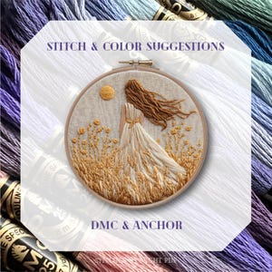 May include: An embroidered artwork in a wooden hoop depicts a woman in a flowing dress, standing in a field of wheat under a sun. The text "STITCH & COLOR SUGGESTIONS" and "DMC & ANCHOR" are visible. Embroidery floss in various colors surrounds the artwork.
