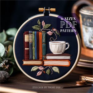 Puede incluir: Un aro de bordado azul con un diseño de una pila de libros, una taza de café y una vid frondosa. El texto "6 SIZES PDF PATTERN" está impreso en blanco sobre un rectángulo rojo. El texto "STITCHER BY NIGHT PDF" está impreso en blanco en la parte inferior del aro.