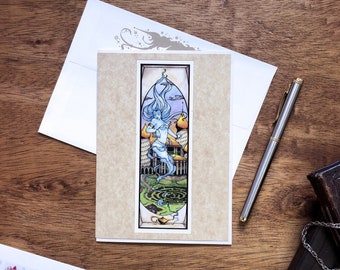 Puede incluir: Una tarjeta de felicitación con una ilustración de estilo vitral de una mujer con el pelo azul ondeante de pie en un laberinto verde en espiral. La tarjeta tiene un fondo beige y un borde blanco.