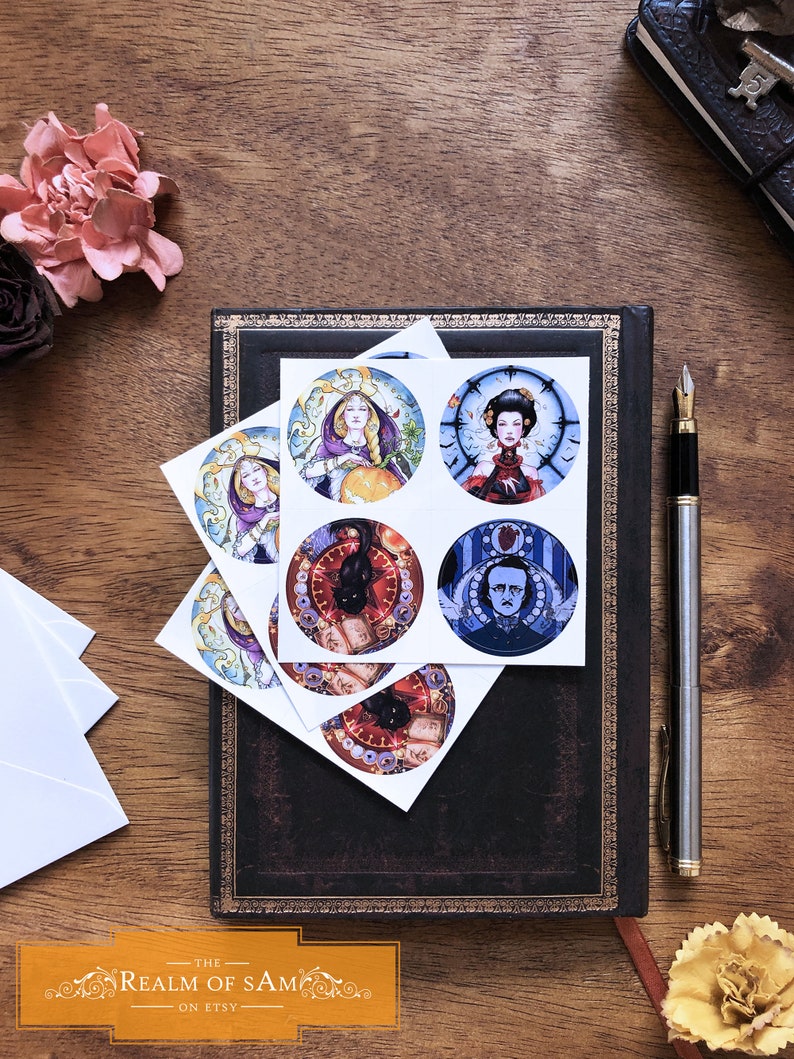May include: Six round stickers with various illustrations. The stickers feature a woman with long blonde hair holding a pumpkin, a woman with dark hair wearing a red dress, a black cat with a clock, a man with a clock, a black cat with a clock, and a black cat with a clock. The stickers are on a dark brown leather journal.