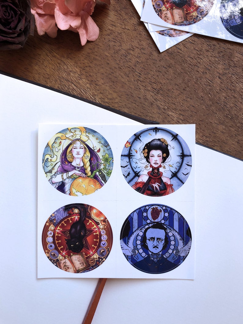 May include: Four round stickers with colorful illustrations. The first sticker features a woman in a purple robe holding a pumpkin. The second sticker features a woman in a red dress with a clock behind her. The third sticker features a black cat on a red background with a book and a clock. The fourth sticker features a man with a beard in a blue suit with a heart and a clock behind him.