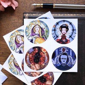 May include: Six round stickers featuring illustrations of a woman with a pumpkin, a woman with a clock, a black cat, a man with a heart, a woman with a clock, and a black cat. The stickers are white with a black border and are arranged in a grid pattern.