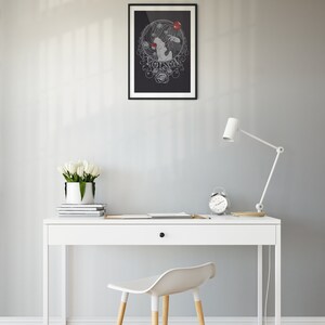 May include: A black and white illustration of a woman with a red apple in her hand. The illustration is surrounded by a circle of roses and the word "Poison" is written in a decorative font. The illustration is framed in black and hanging on a gray wall above a white desk with a white chair.