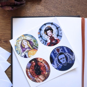 May include: Four round stickers with colorful illustrations. The first sticker features a woman with long blonde hair wearing a purple robe and holding a pumpkin. The second sticker features a woman with dark hair wearing a red dress and a clock behind her. The third sticker features a black cat sitting on a book with a red star and other symbols around it. The fourth sticker features a man with a beard and a white collar wearing a blue suit with a heart and other symbols around him.