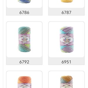 May include: A collection of Alize Cotton Gold yarn skeins in various colors. Each skein is wrapped with a label displaying the brand name and product details. The color variations include blue, yellow, green, purple, and orange. The product codes are visible.