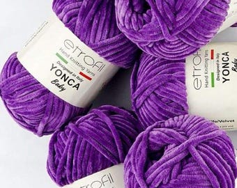 May include: Several balls of vibrant purple velvet yarn. Each ball has a label that reads "etrofil Hand Knitting Yarns, Designed in Italy, YONCA Baby". The yarn is a soft, plush material, ideal for knitting and crochet projects.