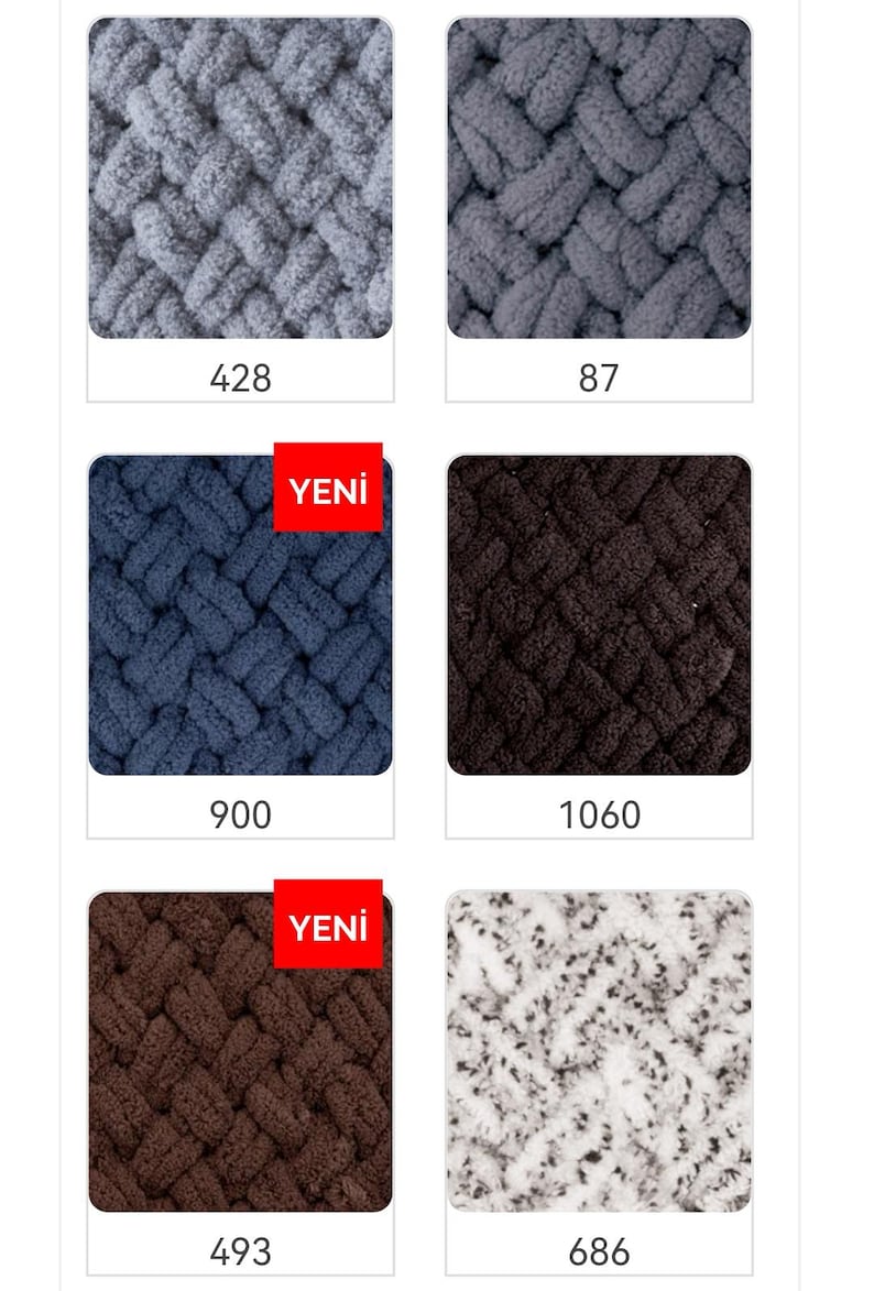 May include: Four different colors of chunky knit yarn, including gray, dark blue, brown, and white with black speckles. The yarn is arranged in a grid pattern with the color number below each sample. The words "Yeni" are printed in red on two of the yarn samples.