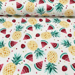 Op de afbeelding: Witte stof met een herhalend patroon van ananas, watermeloenplakjes en aardbeien. De ananas zijn geel met groene bladeren, de watermeloenplakjes zijn rood en groen en de aardbeien zijn rood.