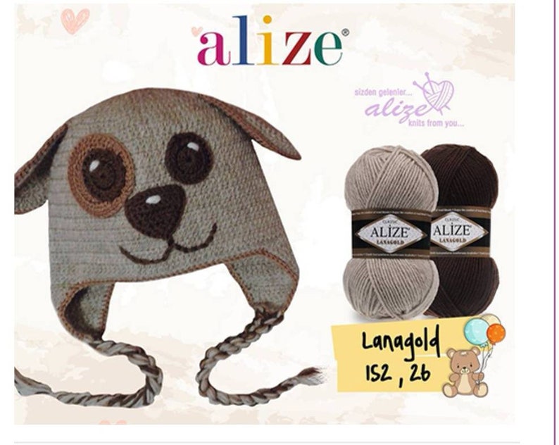 May include: A brown and beige knitted hat with a dog face design. The hat has a long, braided tie. Two balls of yarn are shown in beige and brown. The yarn is labelled "Alize Lanagold 152, 26".