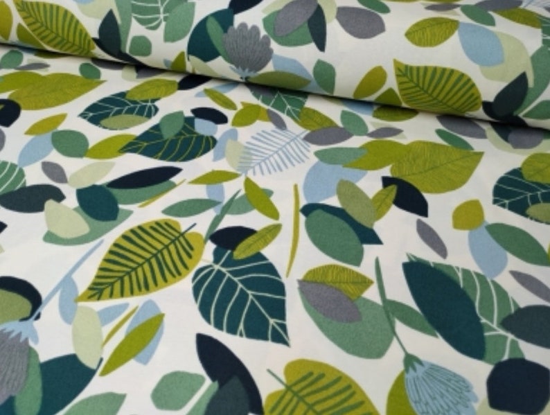 May include: White fabric with a green, blue, and gray leaf pattern. The leaves are stylized and abstract.