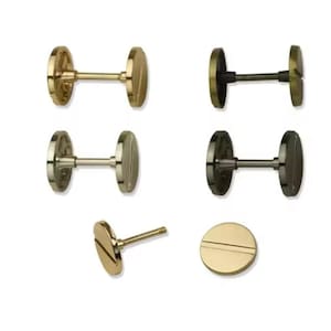 Peut inclure: Une sélection de six boucles d'oreilles à vis en métal, disponibles en finitions or, argent et noir. Chaque boucle d'oreille présente une tête ronde et plate avec une seule rainure et une tige pour la fixation. Une boucle d'oreille est montrée de côté.