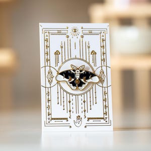 Pin artístico de esmalte con forma de mariposa celestial blanca sobre una tarjeta de aluminio blanca/de bienestar diseñada a medida