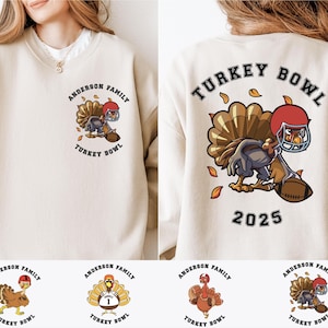 Op de afbeelding: Crèmekleurige sweatshirt met een cartoon kalkoen met een footballhelm en een football. De voorkant van de trui zegt "ANDERSON FAMILY TURKEY BOWL". De achterkant zegt "TURKEY BOWL 2025".