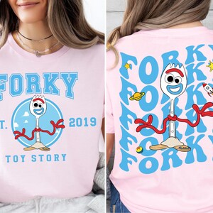 a woman wearing a pink shirt with a cartoon character on it