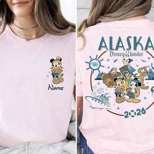 A woman wearing a pink t-shirt with a Disney-themed design, including Mickey Mouse and Minnie Mouse characters, along with the text "Alaska DisneyWonder".