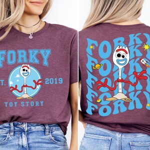 a woman wearing a forky tshirt and jeans