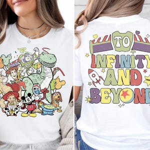 a woman sitting on a couch wearing a white shirt with cartoon characters on it