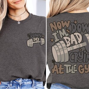 a woman wearing a t - shirt that says now down, i'm bad