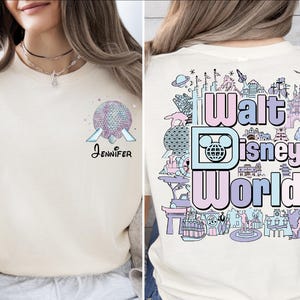 A woman wearing a white t-shirt with a Disney World-themed design on the back.