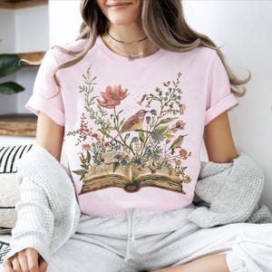 a woman sitting on a bed with a book in her lap