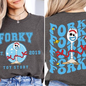 a woman wearing a forky tshirt and jeans