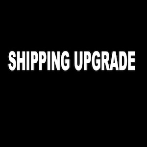 May include: White text on a black background that reads "SHIPPING UPGRADE".