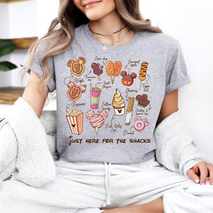 a woman sitting on a couch wearing a t - shirt