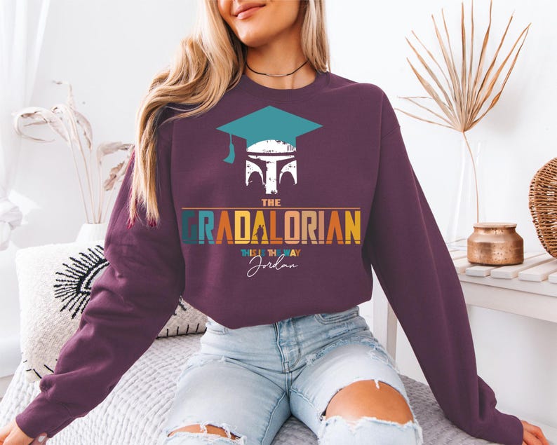 a woman sitting on a bed wearing a purple sweatshirt