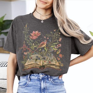 a woman wearing a t - shirt with a picture of a book on it