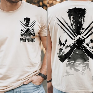 May include: A beige t-shirt with a black and white graphic of Wolverine with his claws extended. The text "WOLVERINE" is printed below the graphic.
