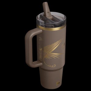 Puede incluir: Un vaso t&eacute;rmico marr&oacute;n con asa y pajita. El vaso presenta un dise&ntilde;o de p&aacute;jaro dorado y una banda dorada alrededor de la parte superior. La tapa es transparente con un cierre abatible marr&oacute;n. Tiene una capacidad aproximada de 887 ml.