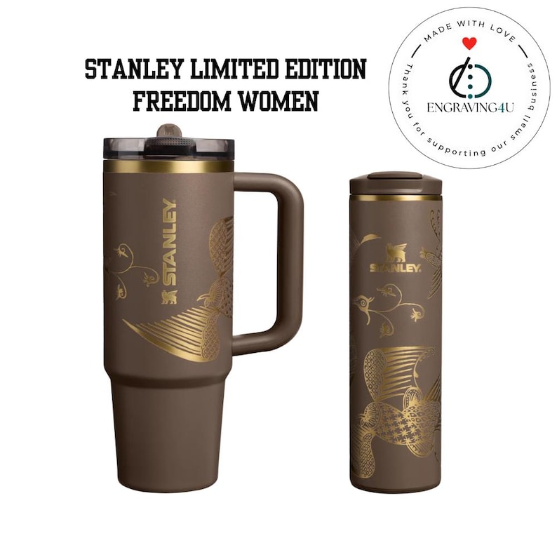 Puede incluir: Dos vasos Stanley Limited Edition Freedom Women marrones. Uno es una taza con asa, el otro es un vaso de viaje. Ambos tienen dise&ntilde;os florales y de p&aacute;jaros dorados. El logotipo de Stanley es visible en ambos. El texto "STANLEY LIMITED EDITION FREEDOM WOMEN" est&aacute; en la parte superior.