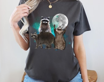 T-shirt con grafica di tre procioni e la luna, colori confortevoli, stile vintage.