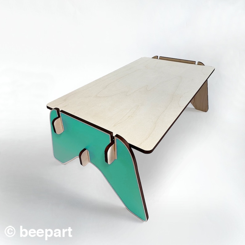 May include: A light wood table with a teal green base. The table is made of plywood and has a simple, modern design.