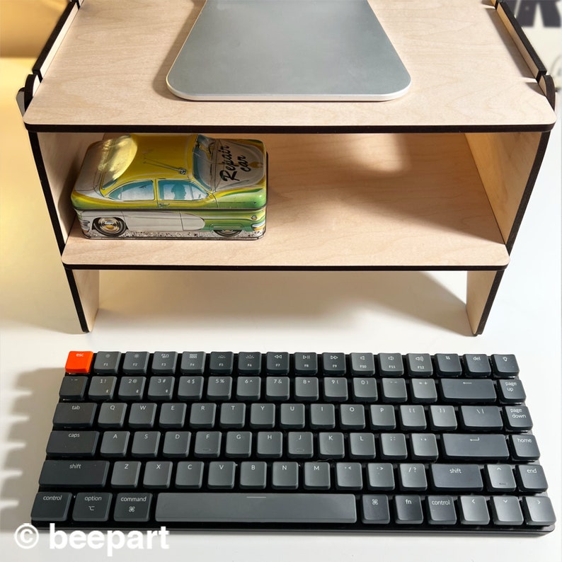 May include: A wooden stand with two shelves, a black keyboard, and a vintage tin box with the words "Repair car" on it.
