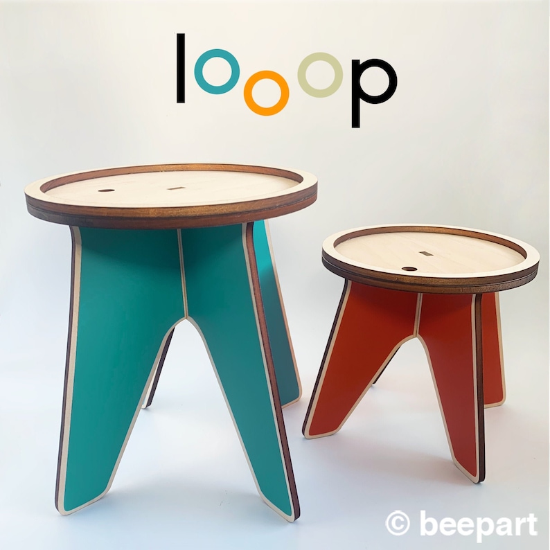 K&ouml;nnte beinhalten: Zwei Holzhocker mit einem einzigartigen Design. Der gr&ouml;&szlig;ere Hocker ist blaugr&uuml;n und der kleinere ist orange. Beide Hocker haben eine runde Holzplatte.
