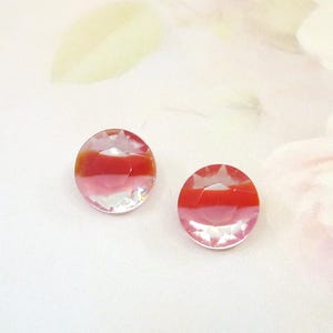May include: Two round, faceted glass cabochons. Each cabochon has a clear, pink, and red colour gradient. The cabochons are circular with a flat back and a domed, faceted top. The colour transitions from clear to pink to red.
