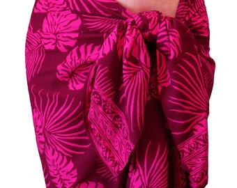 May include: A pink and maroon sarong with a tropical leaf pattern. The sarong is tied at the waist and drapes down to the ankles.
