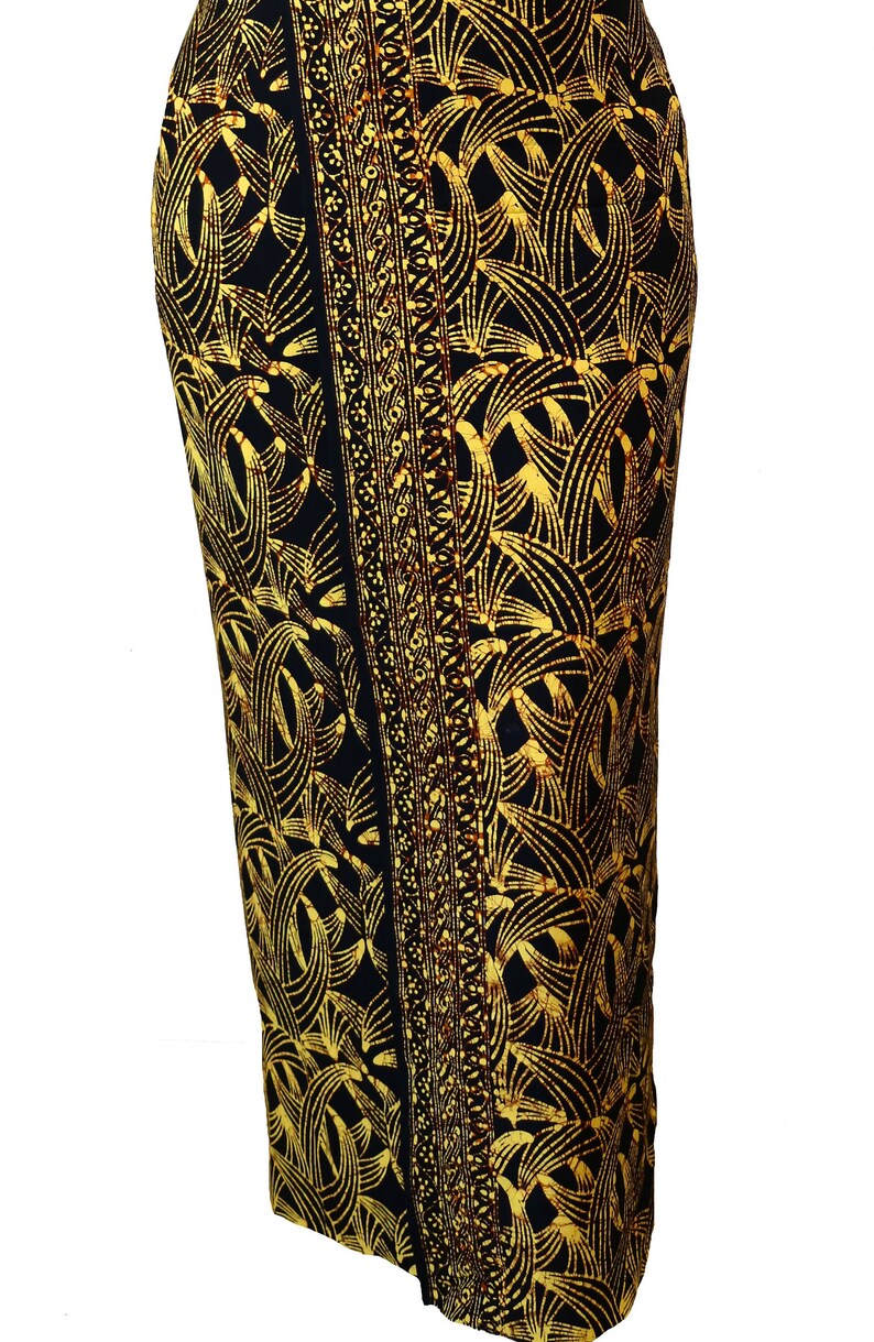 Black sarong in a golden yellow swirling pattern with a hint of brown crackly batik. Shown as a straight skirt with the border pattern draping down the front.
