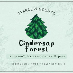 May include: A light green label with the text "STARDEW SCENTS" and "Cindersap Forest". The label features a pixelated green tree graphic. The label also lists the scent notes: bergamot, balsam, cedar & pine. It is made with coconut wax, 255g, and is vegan non-toxic.