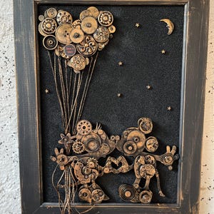May include: A framed artwork featuring a steampunk-style Mickey Mouse figure made of gears and other metal pieces. The figure is holding a heart-shaped balloon made of buttons and gears, and is flying against a black background with gold stars and a crescent moon.