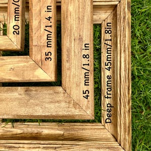 May include: Three wooden picture frames of different sizes, with the measurements in inches and millimeters labeled on each frame. The largest frame is 1.8 inches wide and 45 millimeters deep.