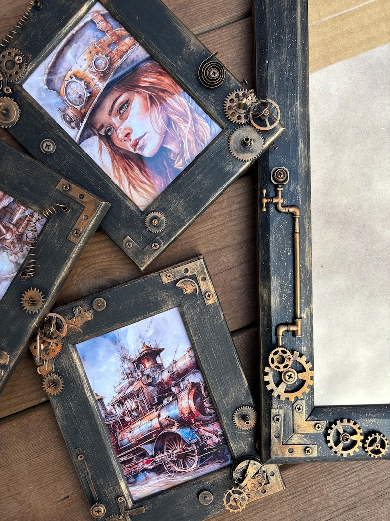 May include: Three black picture frames with ornate gold metal accents and gears. The frames are decorated with a steampunk theme. The frames are on a wooden surface.