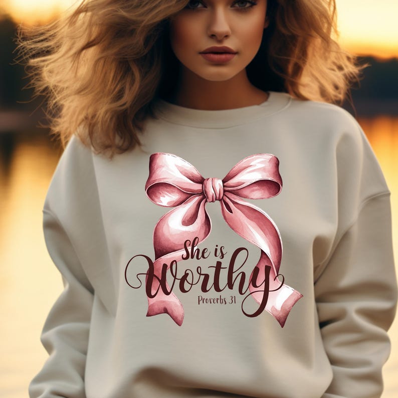 May include: A light beige sweatshirt with a pink bow and the text "She is worthy Proverbs 31" printed on the front.