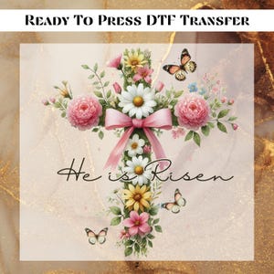May include: A white cross with pink and yellow flowers and butterflies, surrounded by a pink ribbon. The text "He is Risen" is written in cursive below the cross.