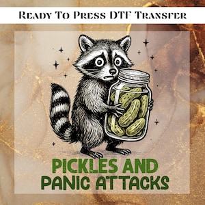 May include: DTF transfer featuring a distressed raccoon holding a jar of pickles. The raccoon has a worried expression. Text at the bottom reads "Pickles and Panic Attacks". The top text reads "Ready to Press DTF Transfer".