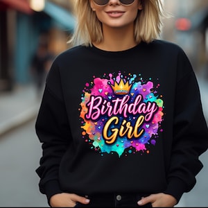 May include: Black sweatshirt with a colorful watercolor design featuring a crown and the text "Birthday Girl".